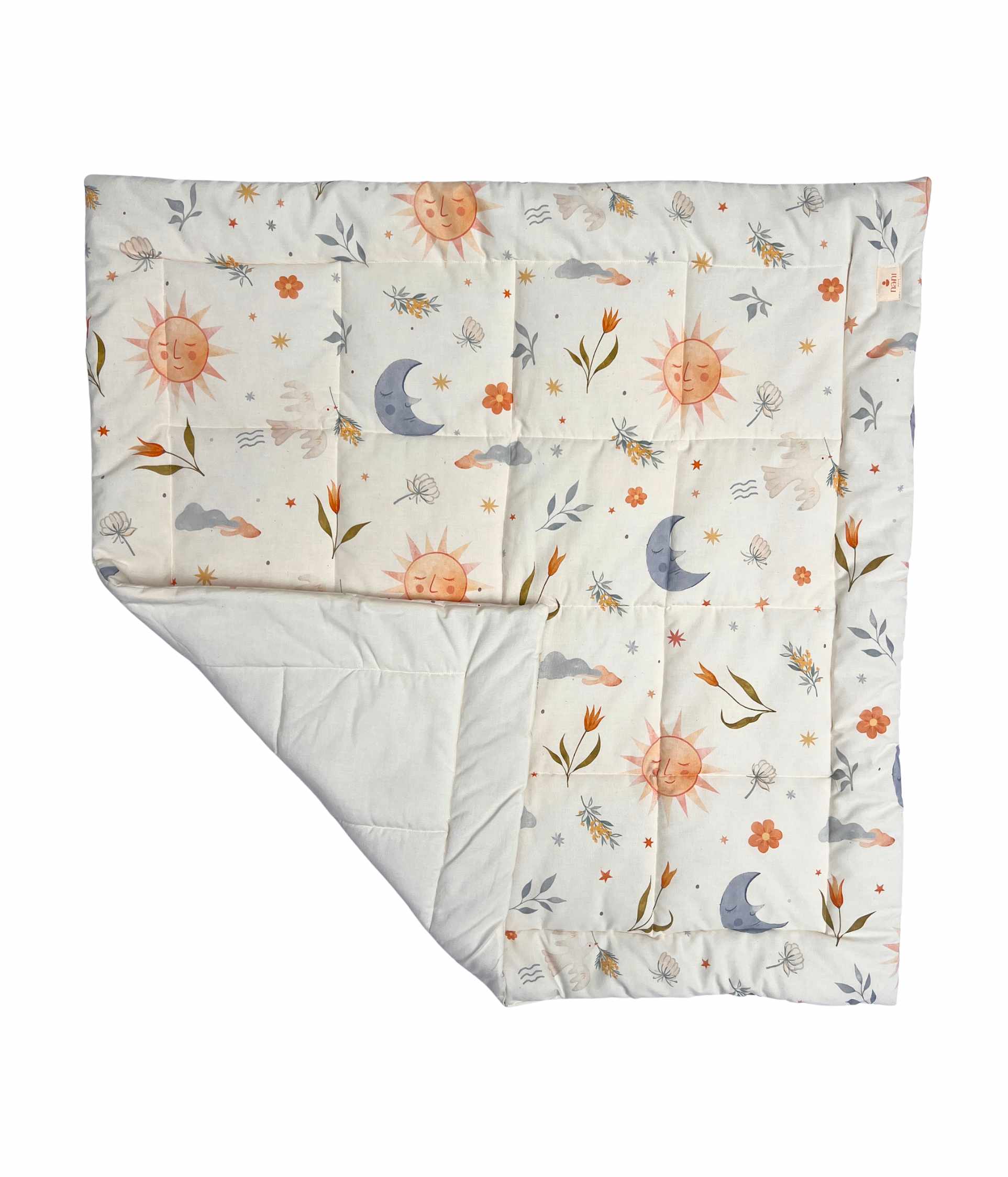 
A quilted baby blanket with a whimsical celestial and floral pattern, featuring orange smiling suns, blue crescent moons, and small flowers on an off-white background. The underside is solid off-white.